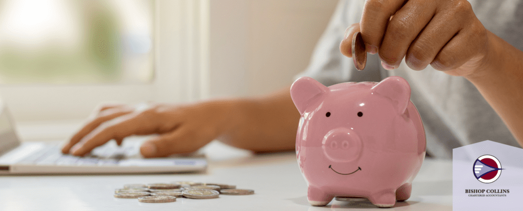 person adding coins to piggy bank