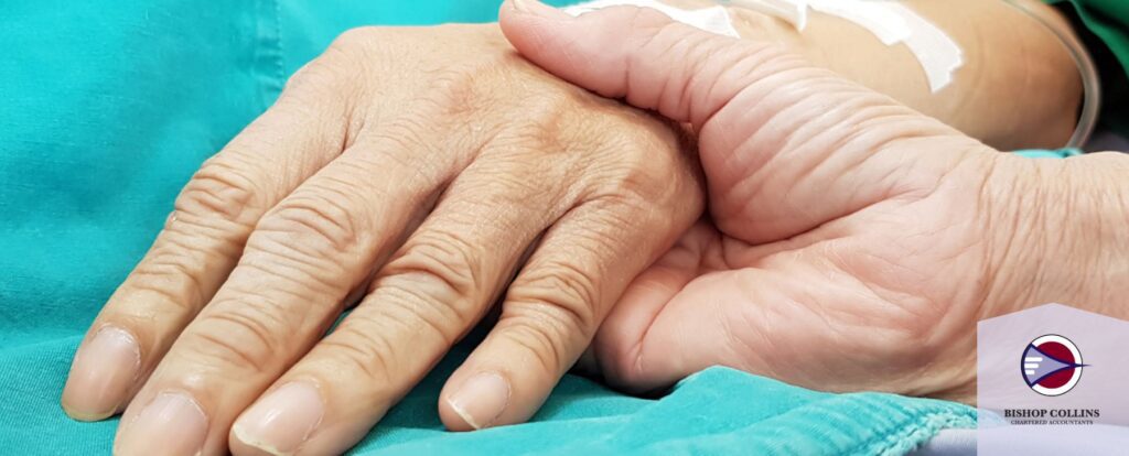 A caring hand holds an elderly hand.