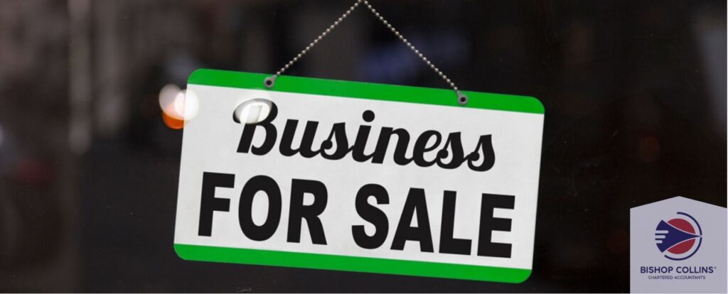 A sign is up in a window with business for sale