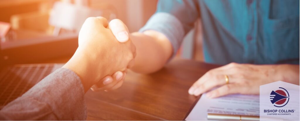 Tax accountant hand shaking representing a partnership between a business owner and a tax accountant